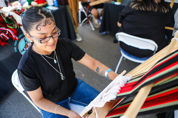Indigenous Girl Displays Traditional Blanket Weaving