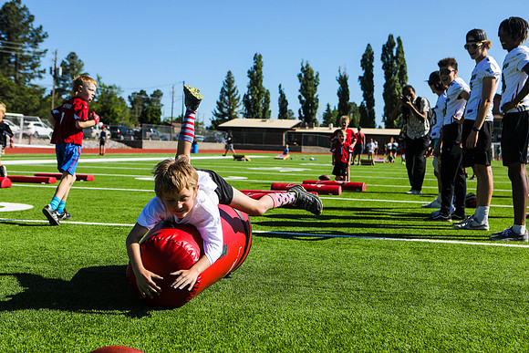 A Young Boy Takes a Go at Football Warmups